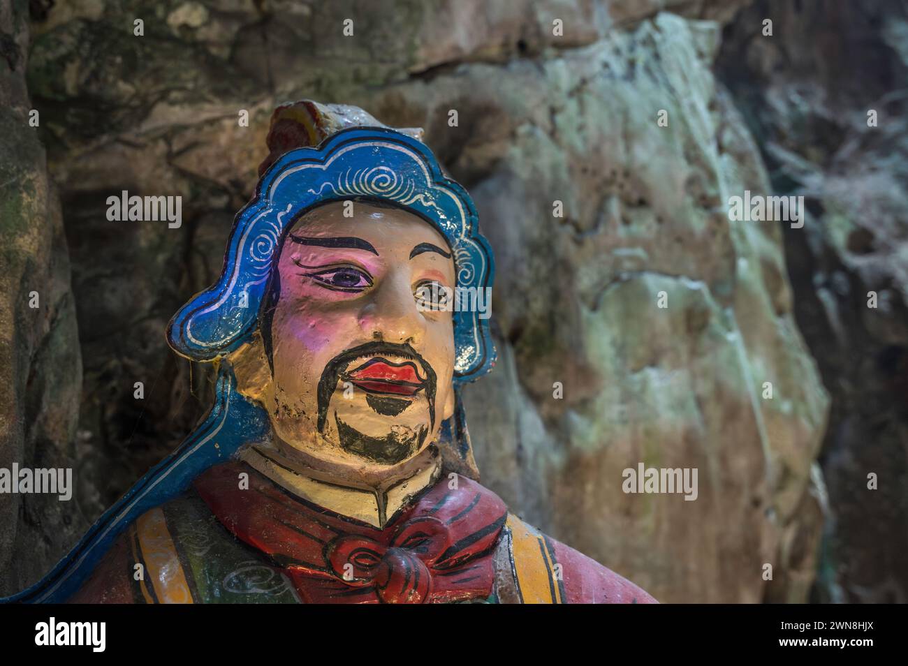 A colourful statue of a religious figure, located in a temple, in a