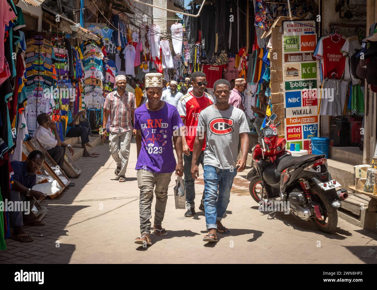 Young men walk in Darajani Market in Zanzibar City, Zanzibar, Tanzania Stock Photo
