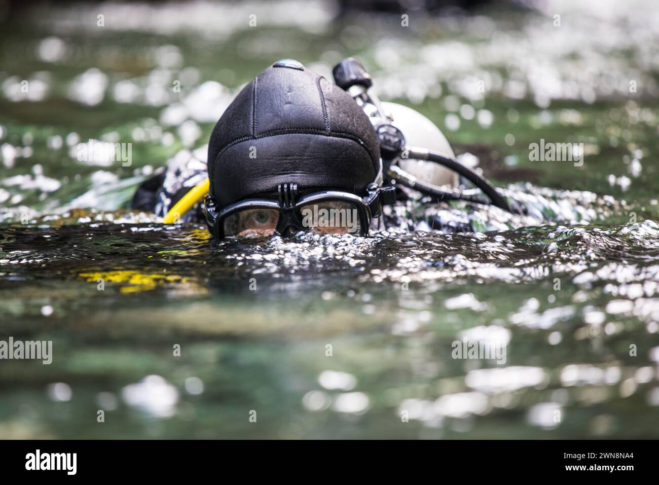 Suba diver surfaces after a dive, goggles protecting eyes Stock Photo
