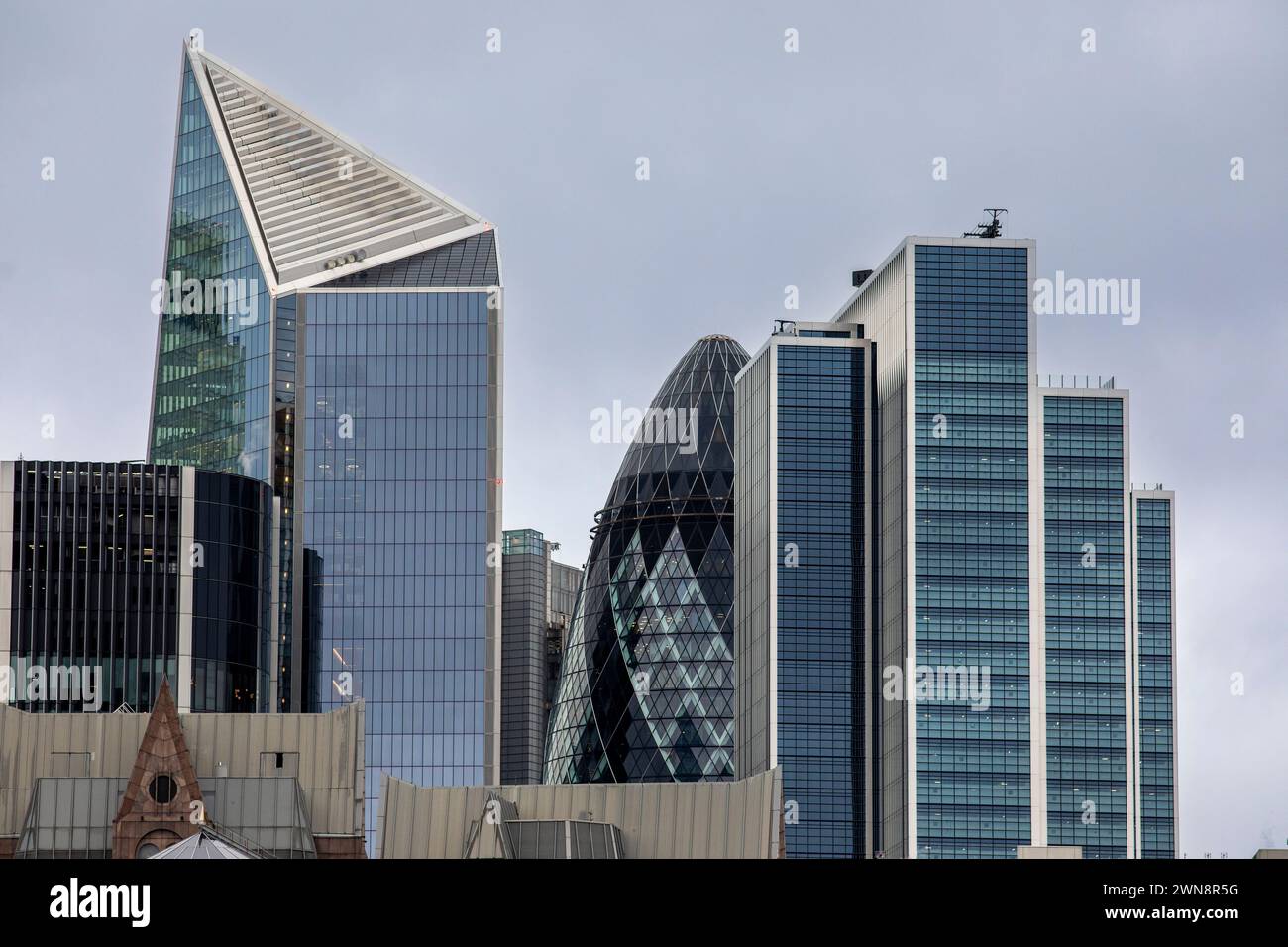 The London city skyline with the iconic Gherkin building framed by the modern buildings that surround it. The Gherkin, formally 30 St Mary Axe and previously known as the Swiss Re Building, is a commercial skyscraper in London's primary financial district, the City of London. It was completed in December 2003 and opened in April 2004.[10] With 41 floors, it is 180 metres (591 ft) tall[3] and stands on the sites of the former Baltic Exchange and Chamber of Shipping, which were extensively damaged in 1992 in the Baltic Exchange bombing by a device placed by the Provisional IRA . Stock Photo