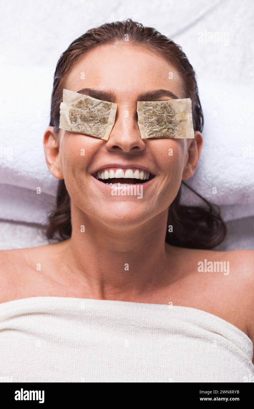 Woman relaxing with teabags on eyes Stock Photo