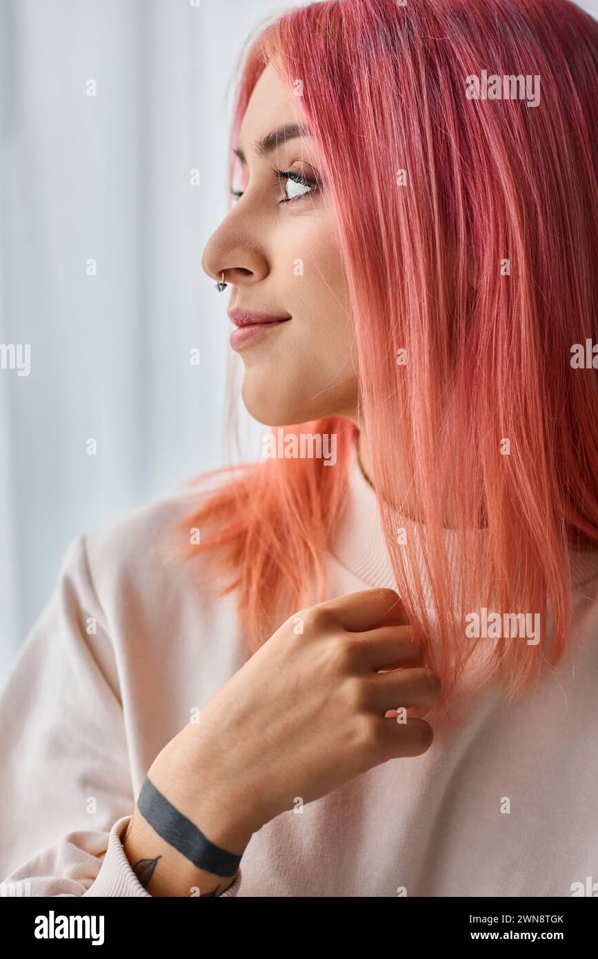 beautiful jolly young woman in white jumper with pink vivid hair posing in kitchen and looking away Stock Photo