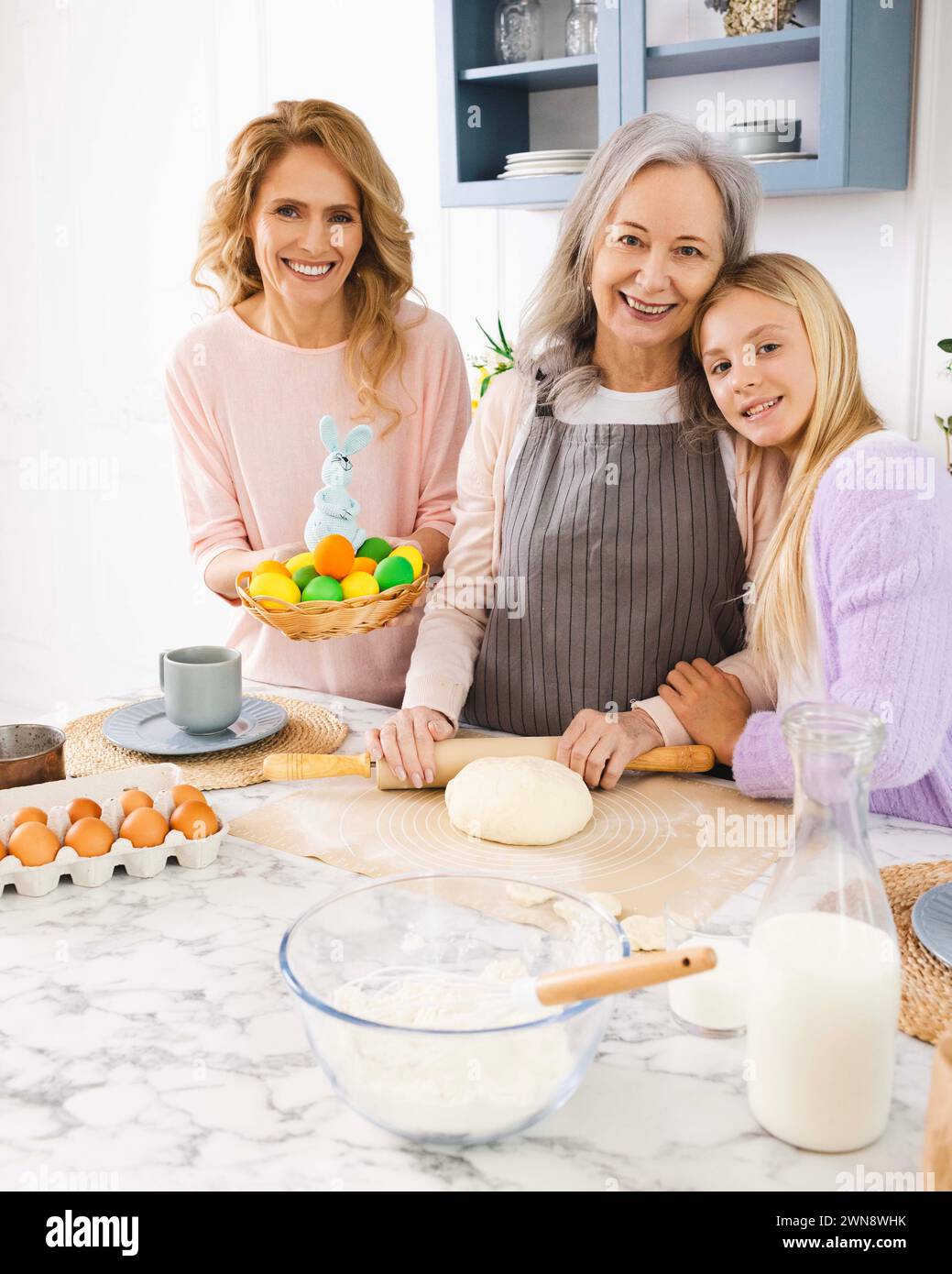Happy Easter. Women of three generations making Easter cake and holiday dinner in cozy kitchen Stock Photo