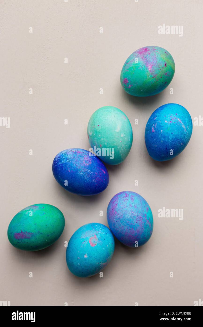 Blue and green dyed Easter eggs against pink backdrop Stock Photo