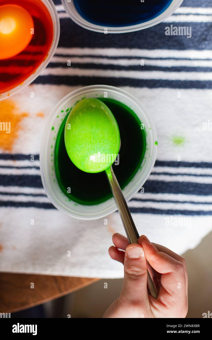 Green dyed Easter egg on a metal spoon Stock Photo