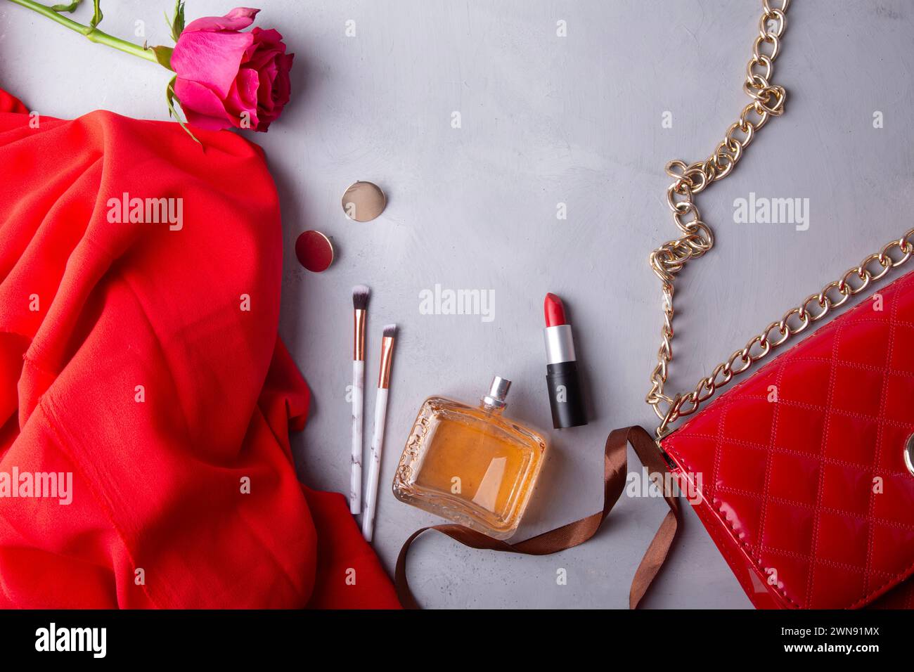Feminine essentials perfume, lipstick, make up brushes and fresh flowers. Stock Photo