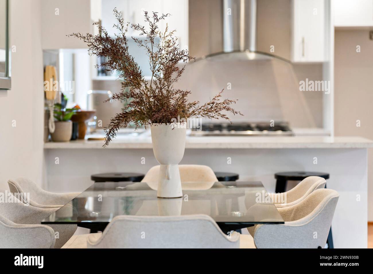 A dining table set with chairs and a vase of flowersd Stock Photo - Alamy