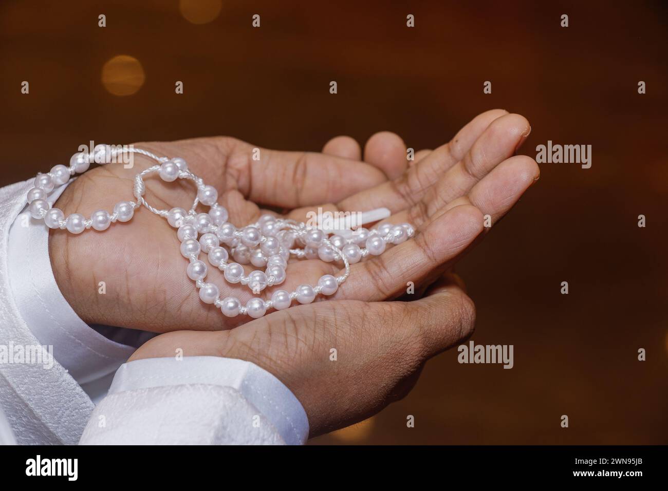 A closeup shot of a person holding rosary beads Stock Photo