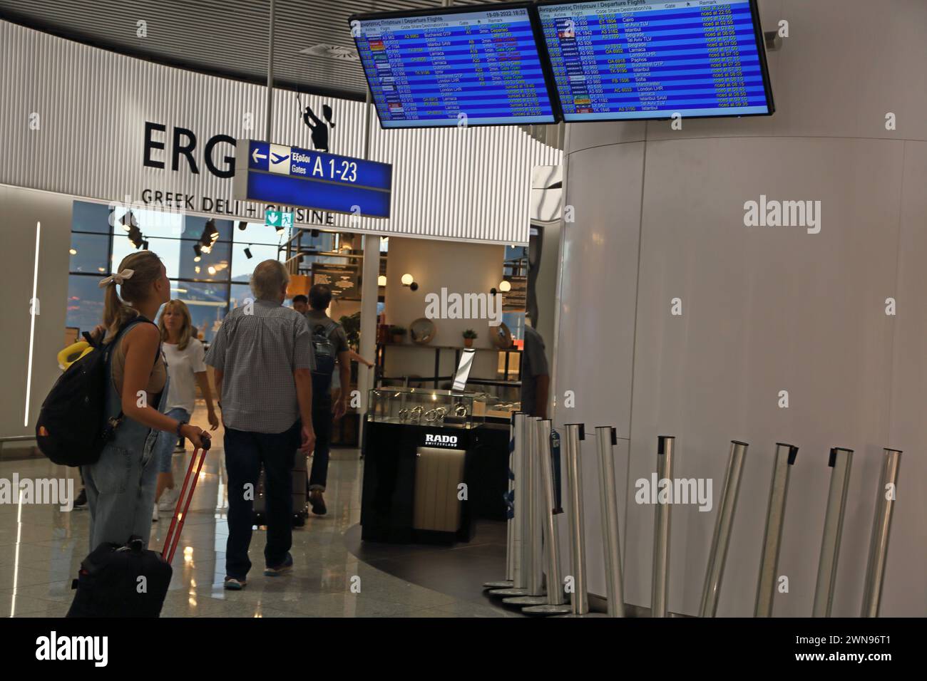 Athens Greece Athens International Airport (AIA) Eleftherios Venizelos Woman with Suitcase looking at Departure Flight Times Stock Photo