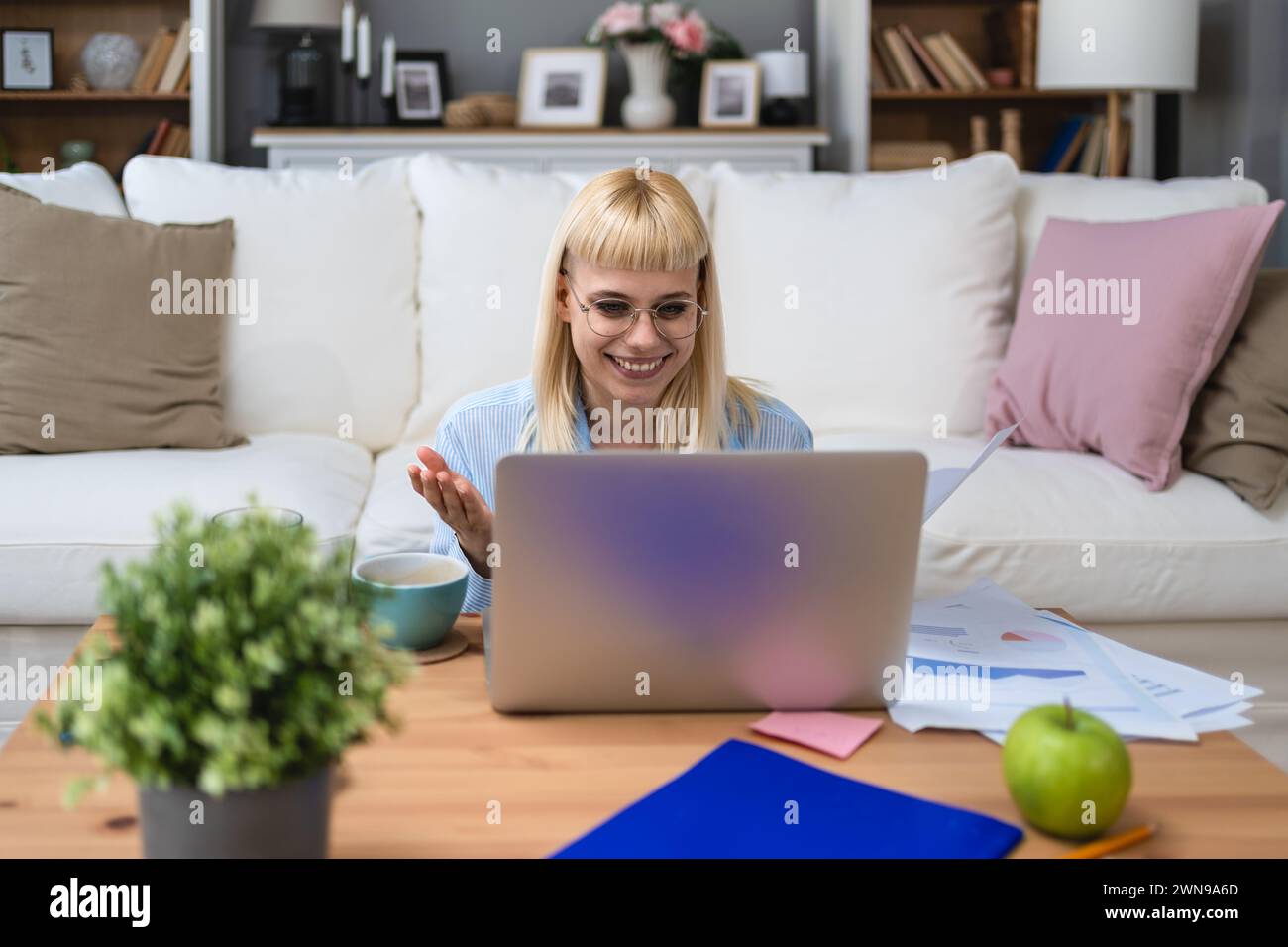 Young business woman freelance expatriate financial and digital marketing expert in smart casual working at home in home office having video call on l Stock Photo