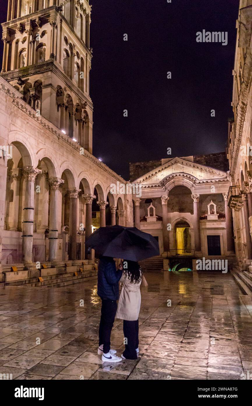 A couple under an umbrella in the rain in the peristyle at night, Diocletian's palace, Split, Croatia Stock Photo