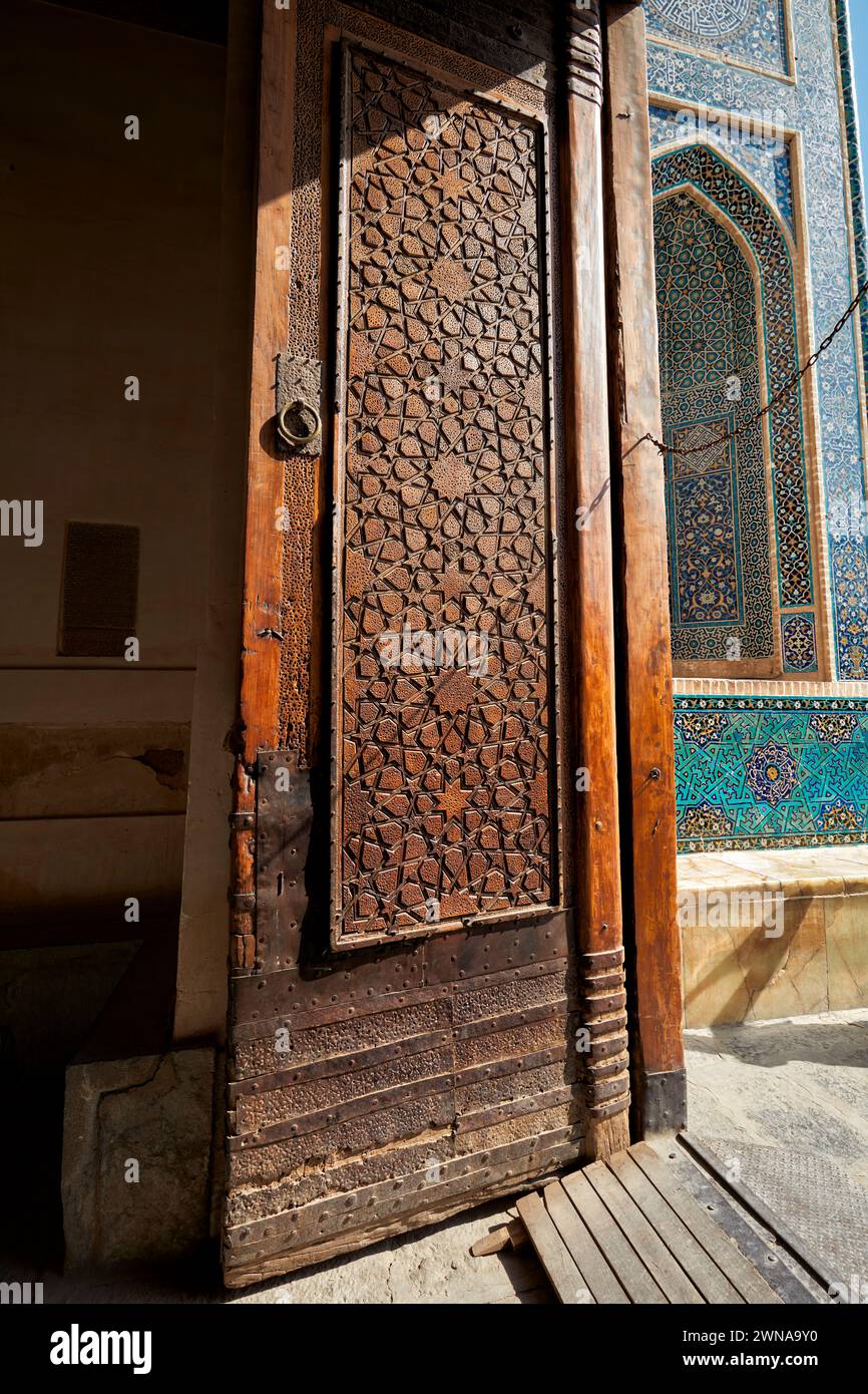 Massive old wooden door with elaborate carving in the Jameh Mosque of Yazd, 14th-century Azeri-style Shia mosque in the Old Town of Yazd, Iran. Stock Photo