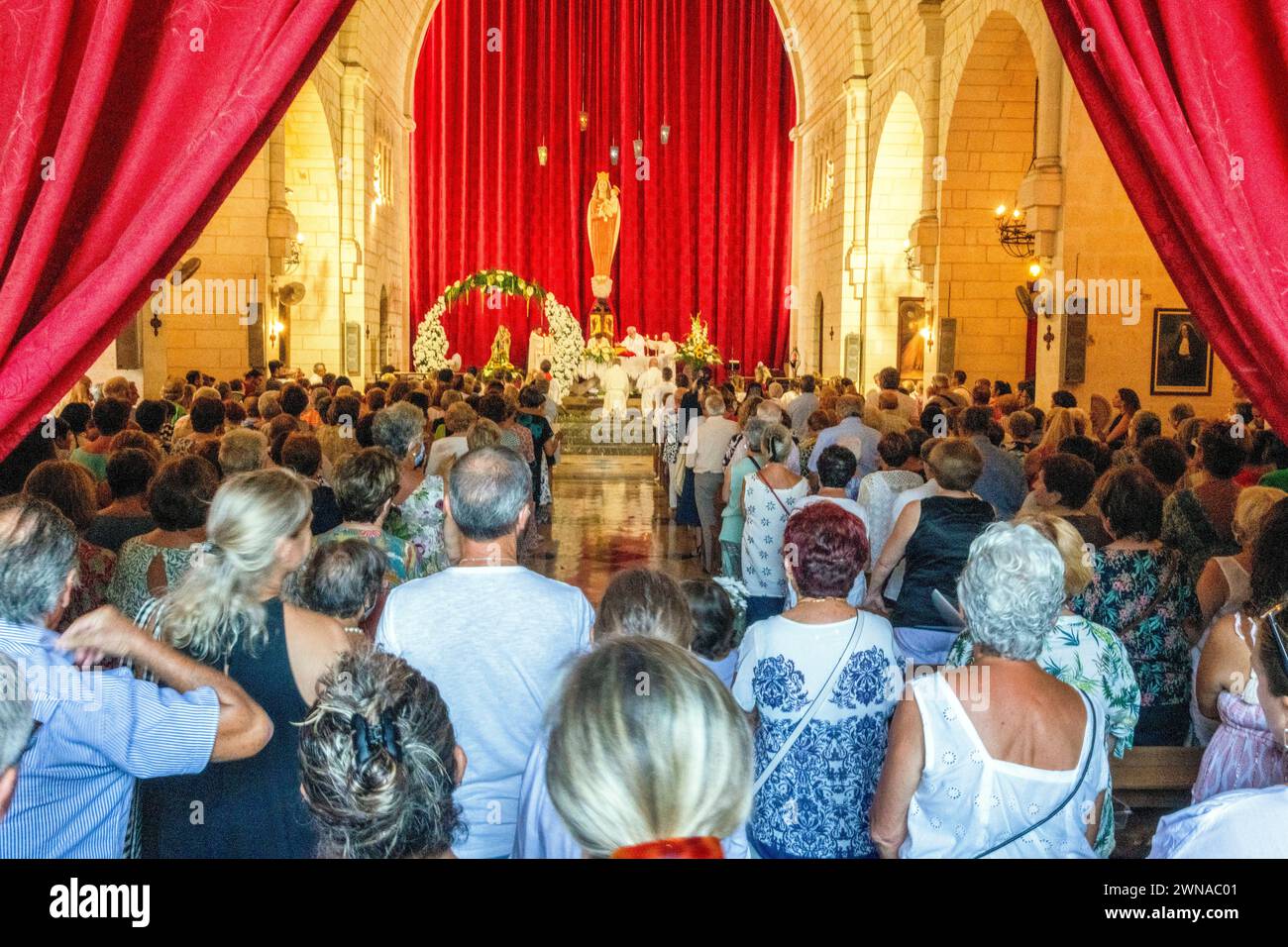 Crowd in the village church of Porto Cristo, Mallorca. Stock Photo