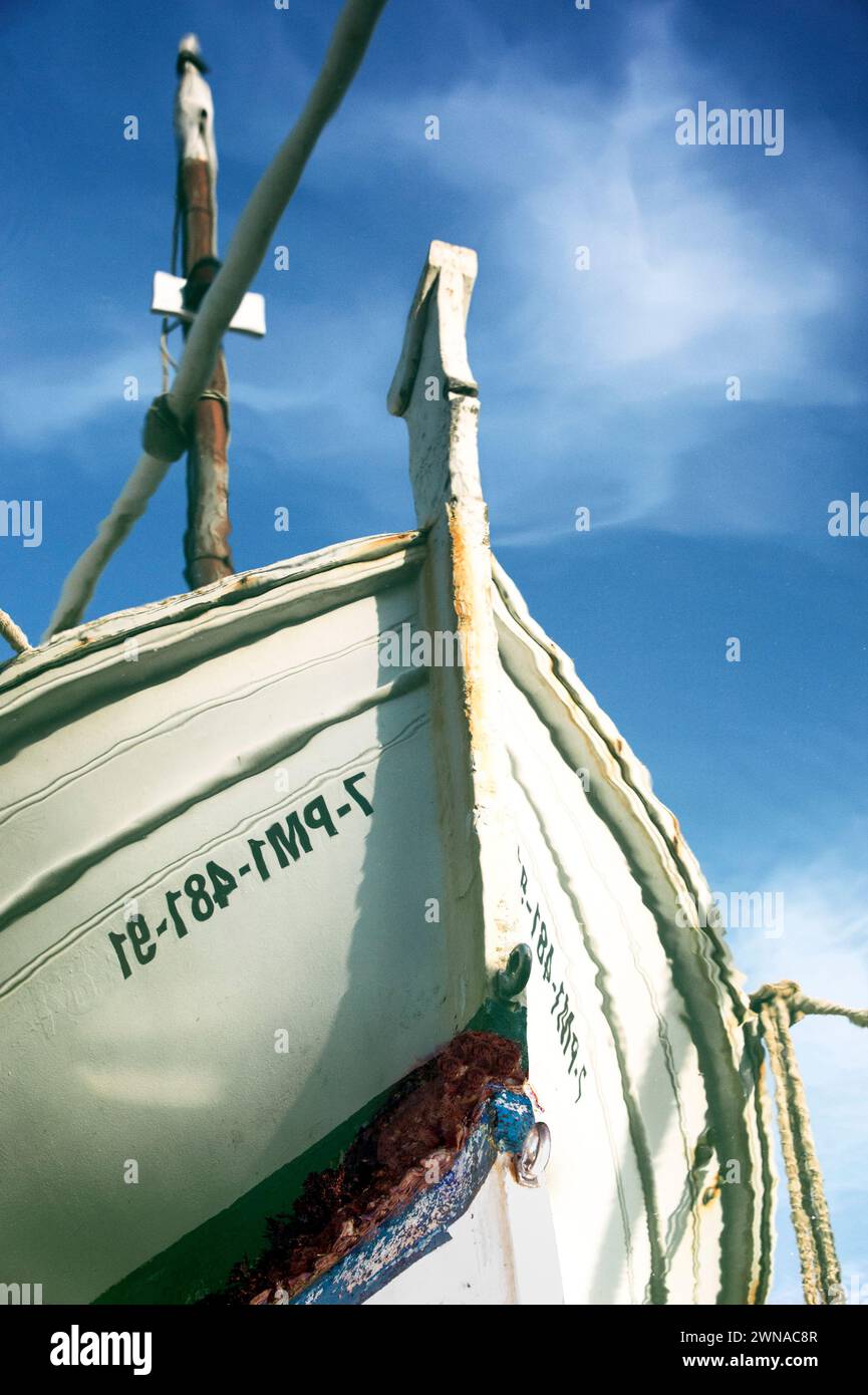 A traditional Mallorcan fishing boat (mall: Llaüt) is reflected in the harbour basin of Porto Cristo. Stock Photo