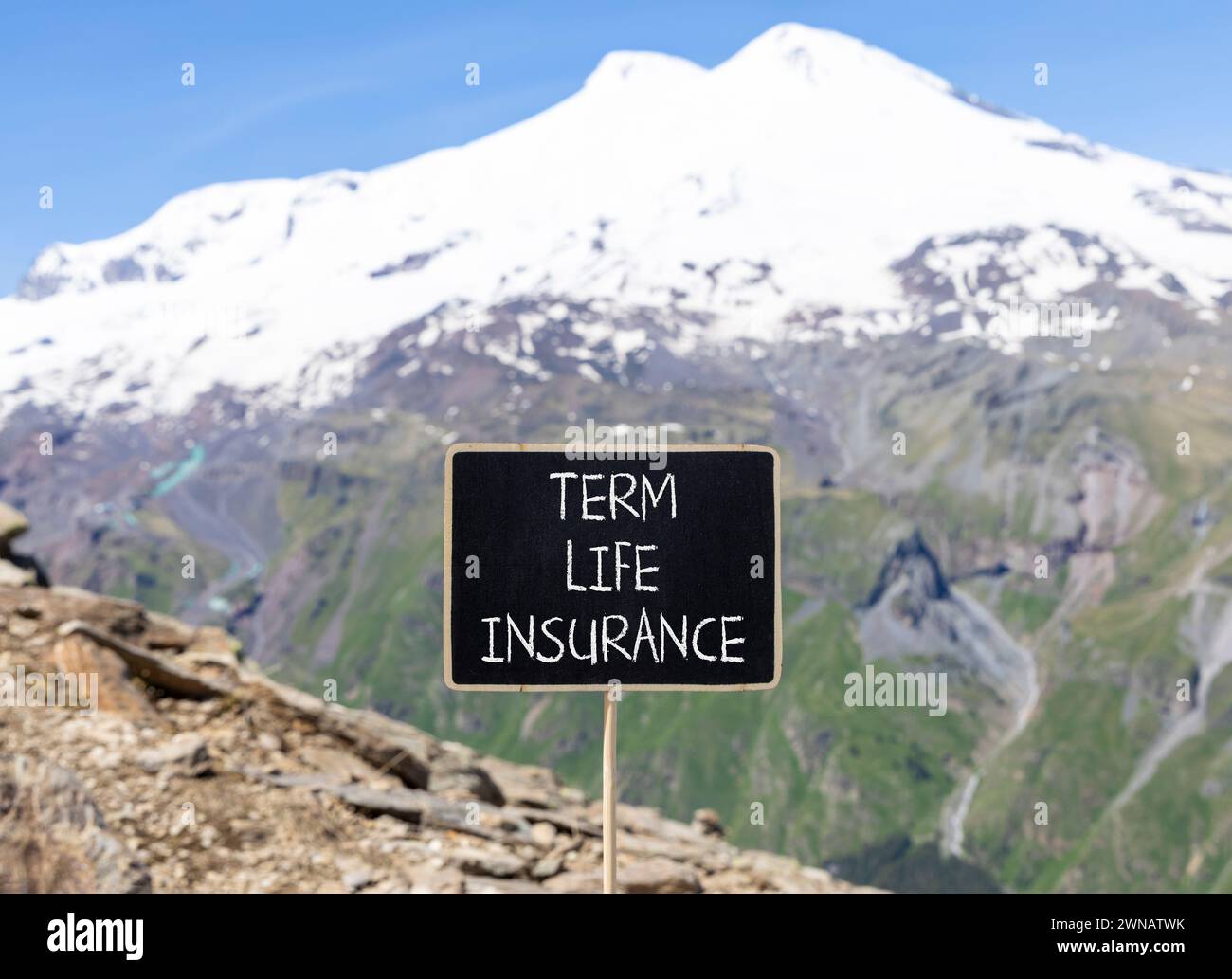 Term life insurance symbol. Concept words Term life insurance on beautiful black chalk blackboard. Beautiful mountain Elbrus background. Medical term Stock Photo