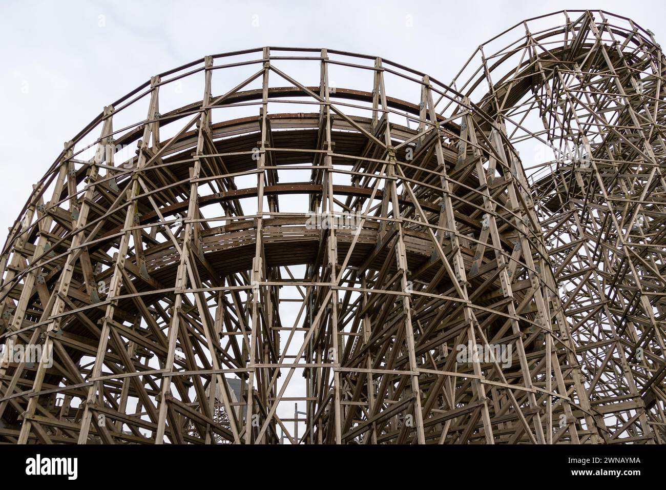 Roller coaster structure with wooden beams rising high into the sky. No ...