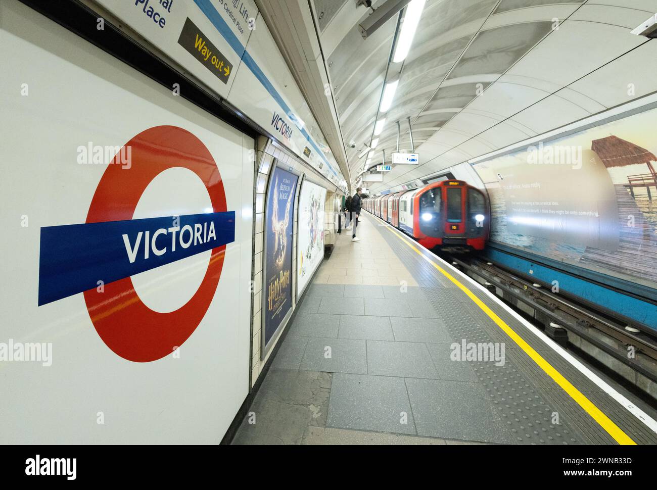 Victoria Underground station London - Victoria Tube station sign, platform and train approaching, public transport for London, London UK Stock Photo