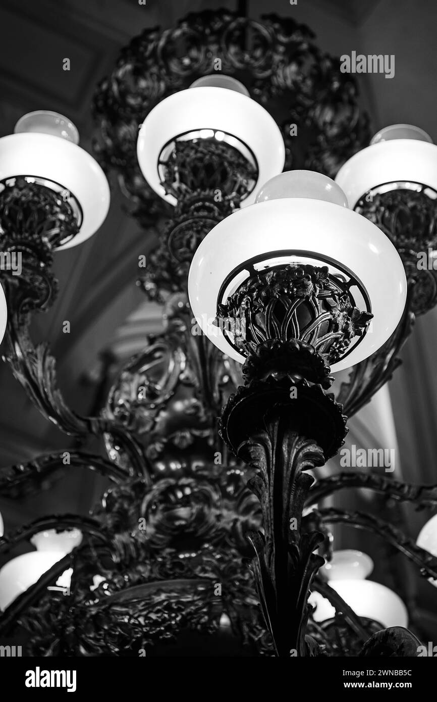 black and white details of a brass chandelier hanging from the ceiling Stock Photo
