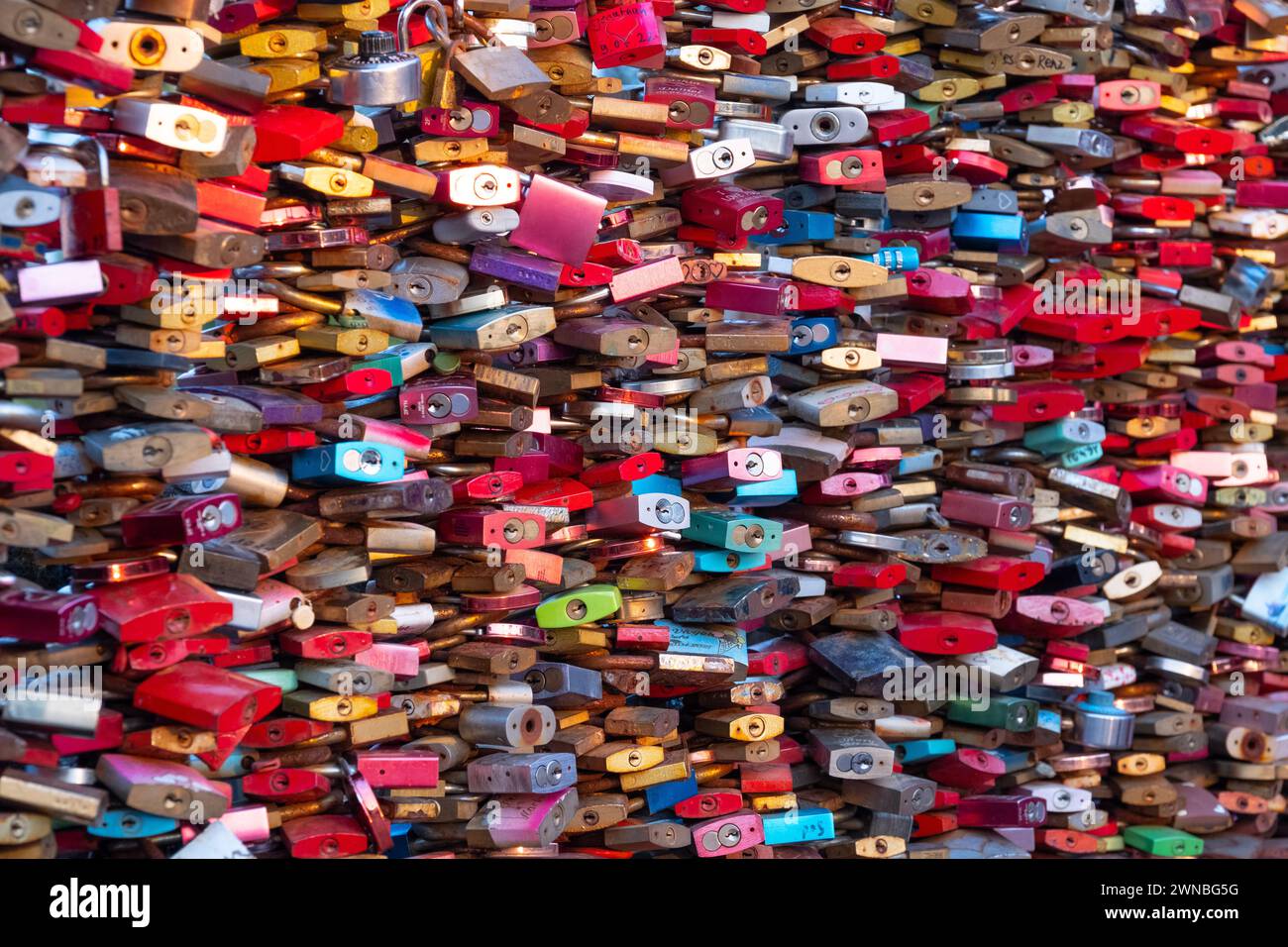 Thousands of multi colored padlock Love Locks squeezed together tightly and filling the frame, on the Hohenzollern Bridge at Cologne, Germany. Stock Photo