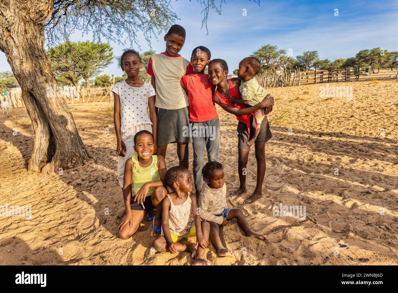 family group of happy african kids , in the village, standing in the yard sandy area in front of the backyard Stock Photo