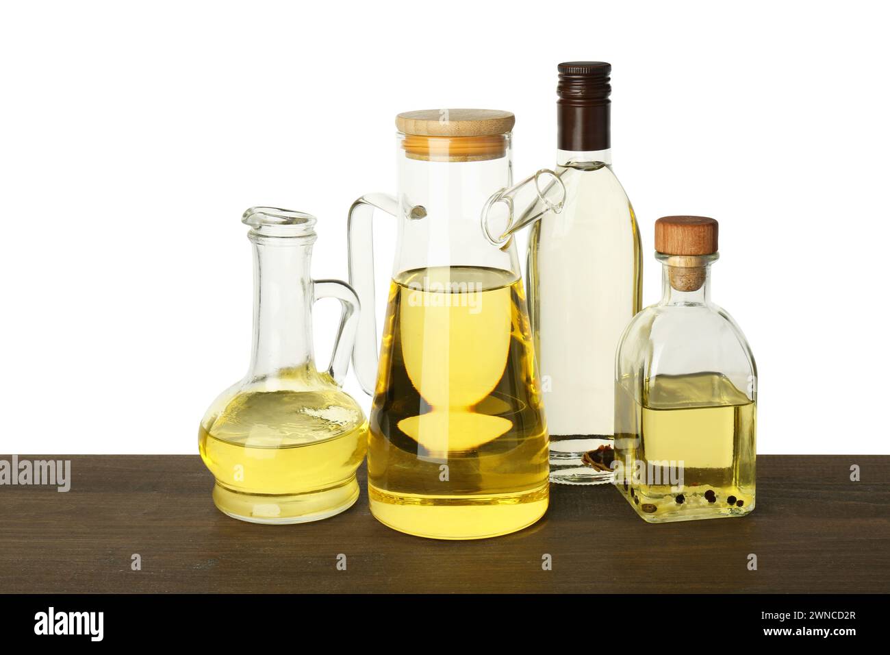 Vegetable fats. Different cooking oils on wooden table against white