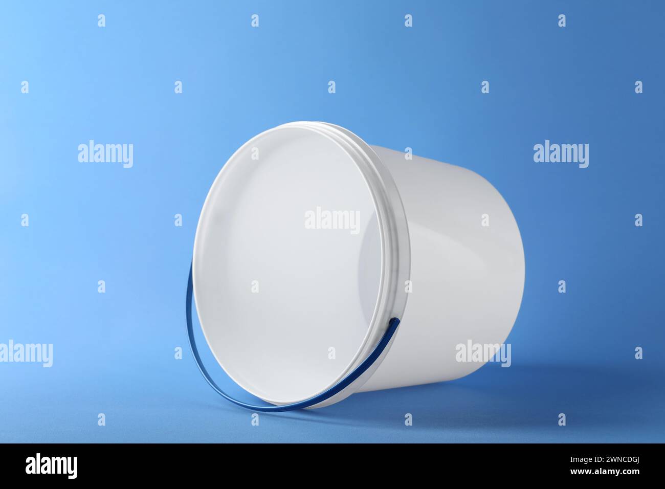 One empty plastic bucket on light blue background Stock Photo