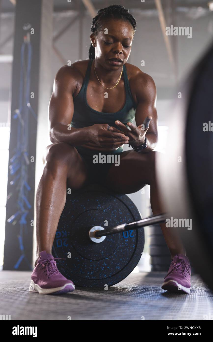 Biracial woman in gym gear shows strength and dedication. Stock Photo