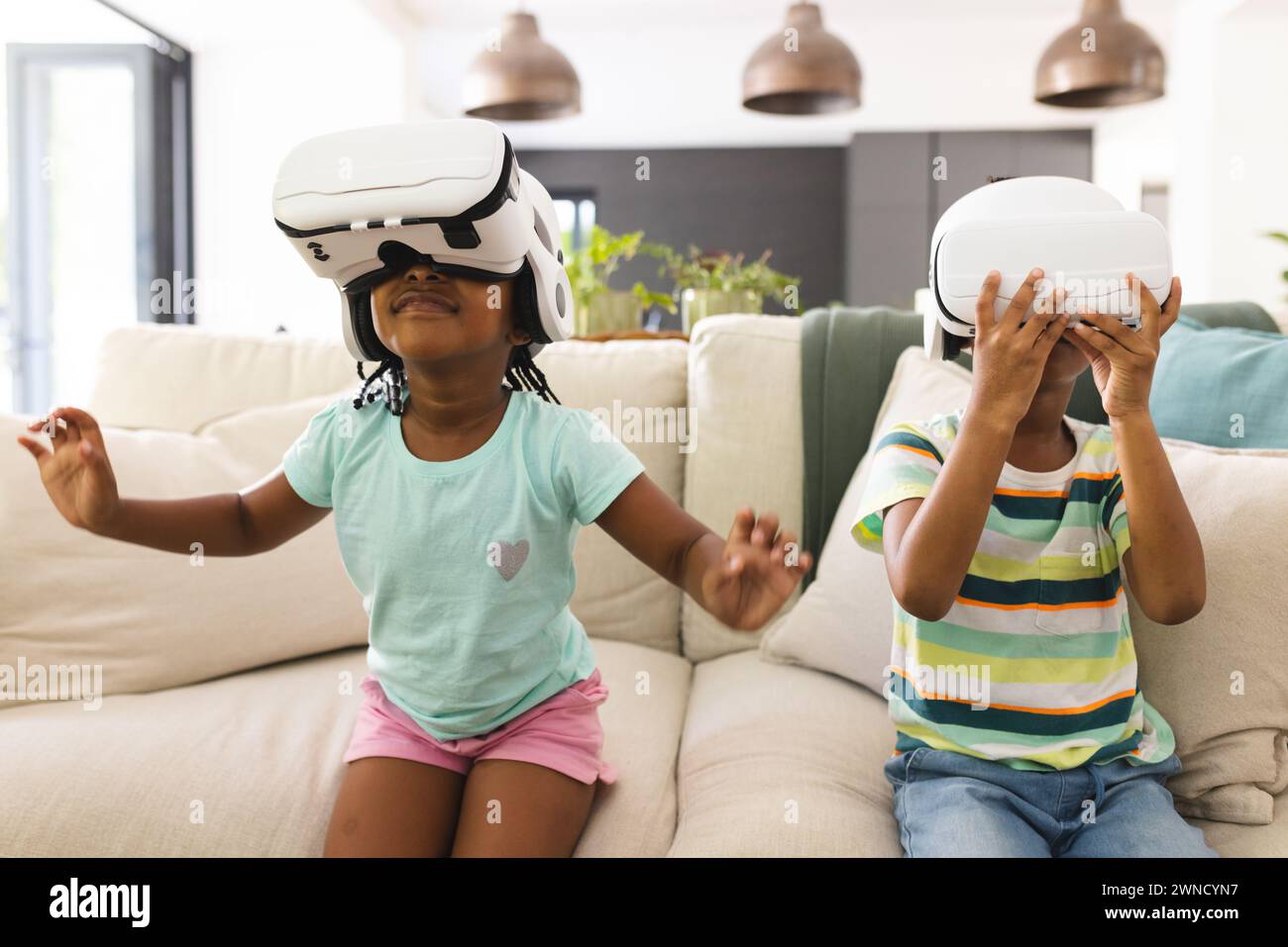 African American sister and brother are immersed in virtual reality ...