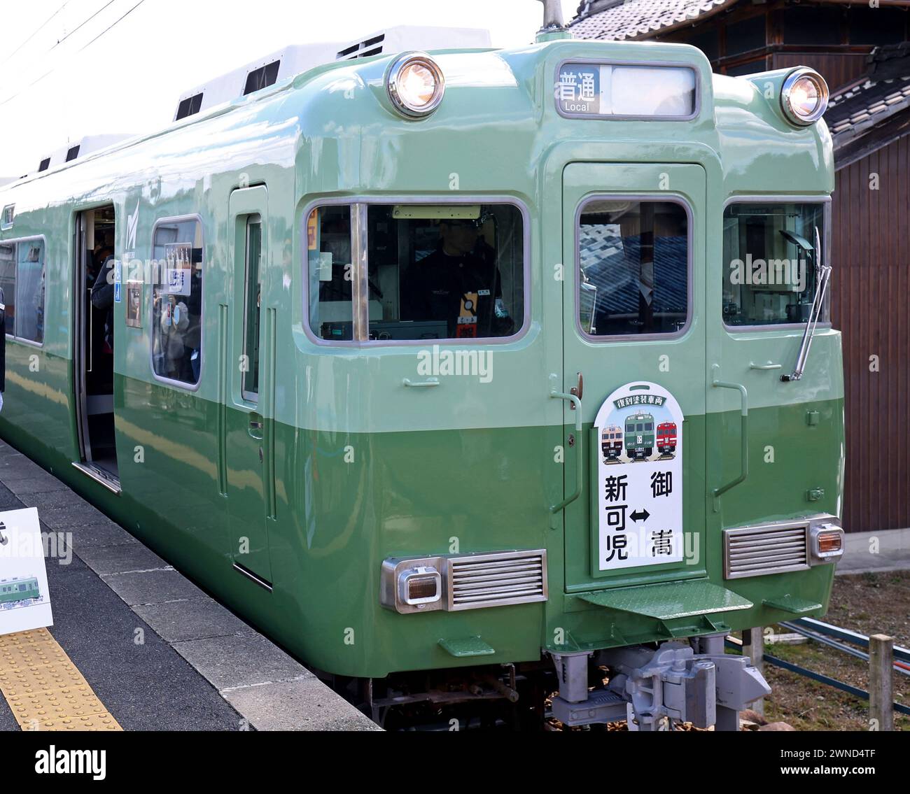 Trainspotters crowd the Mitake Station to see a reprint painting train ...