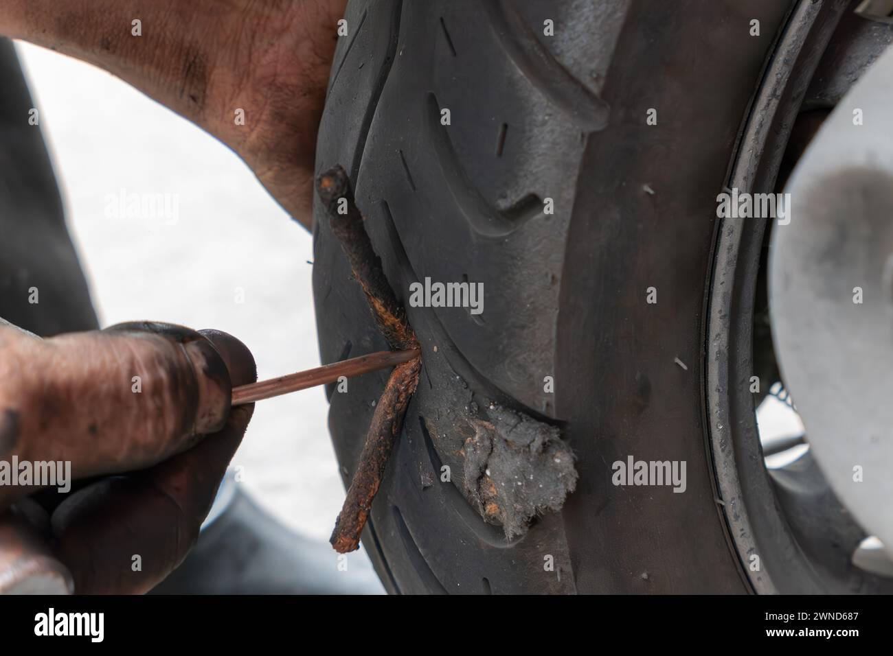 a professional repairman installing a patch and fixing a tire Stock Photo