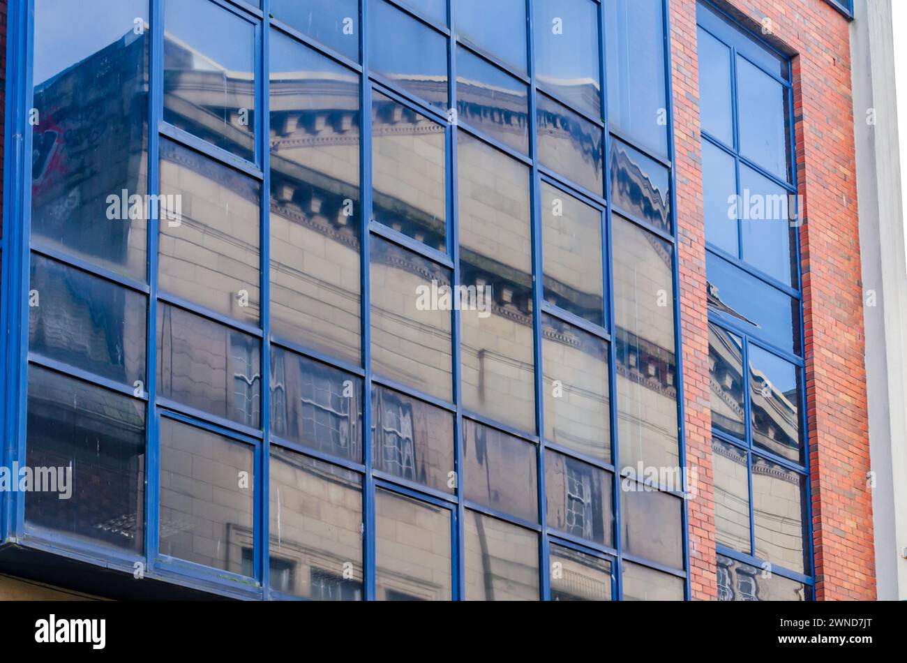 Belfast County Antrim Northern Ireland February 23 2024 -Reflections of an old building in a modern building window Stock Photo