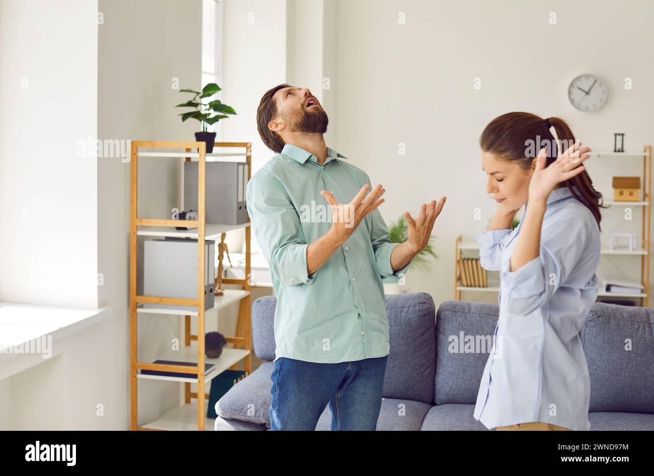 Upset young couple quarreling in the living room at home. Relationship and divorce concept. Stock Photo