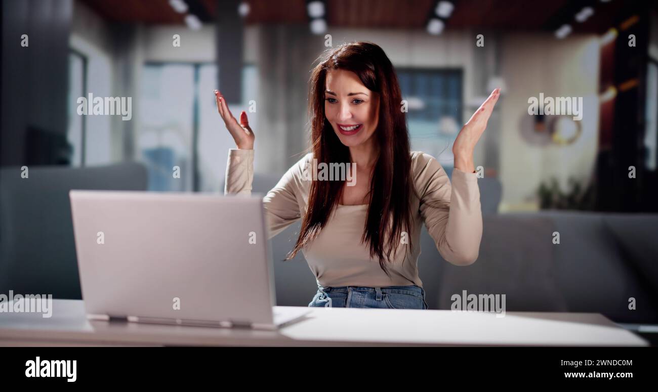 Women With Laptop Computer Celebrating At Home Stock Photo