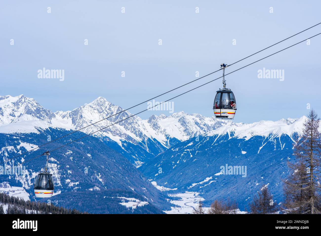 KRONPLATZ, ITALY - JANUARY 21, 2024: Cable car takes skiers and snowboarders to the top of a mountain at the Kronplatz, a popular winter sports destin Stock Photo