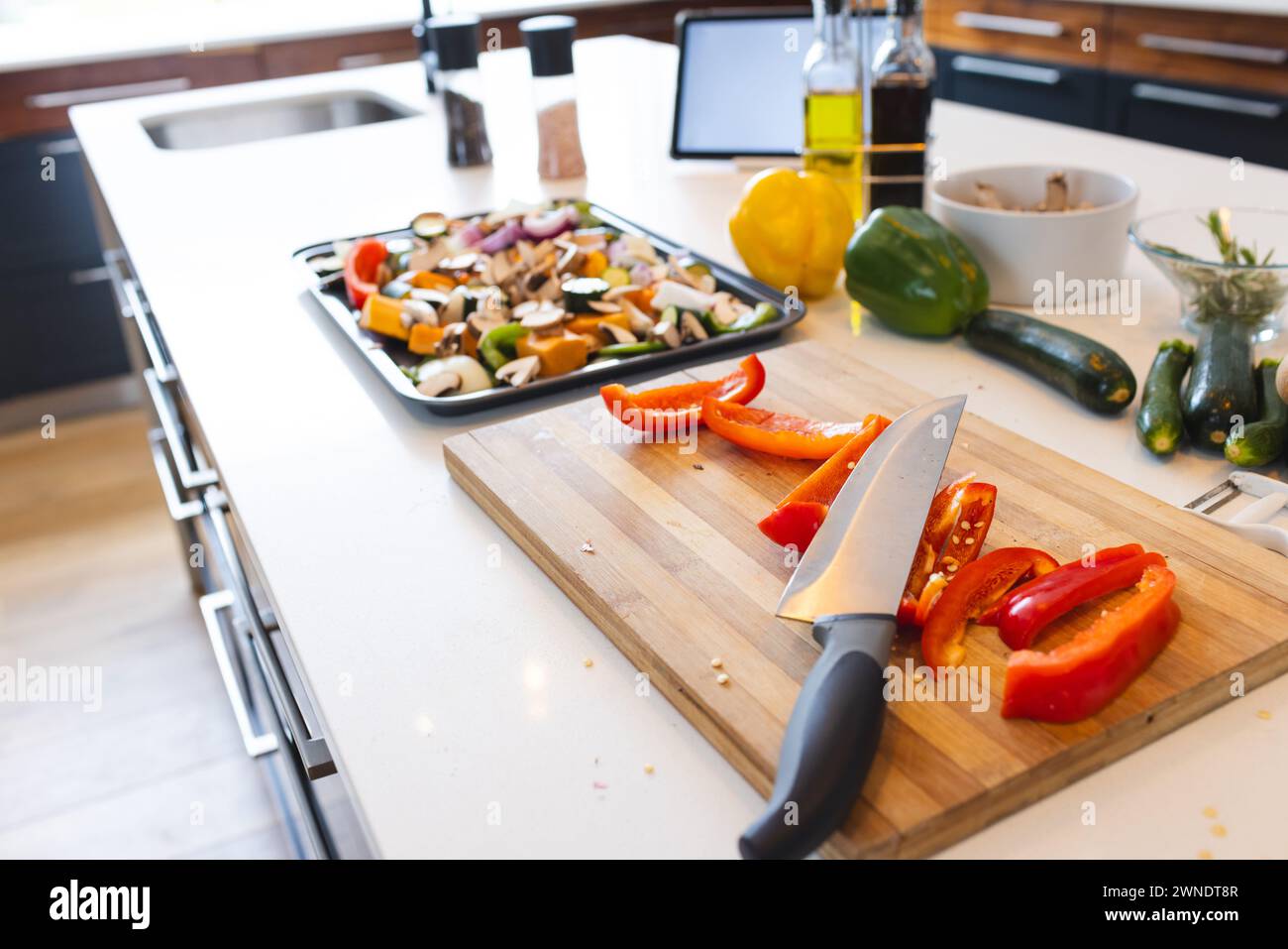 A kitchen counter displays chopped vegetables and a knife on a cutting board Stock Photo