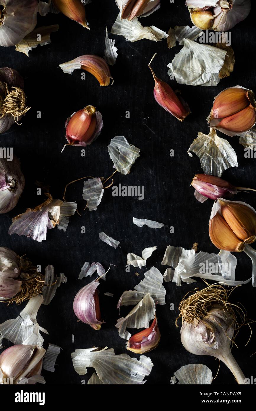 Fresh garlic bulbs and cloves grouped on black background. Flat lay ...