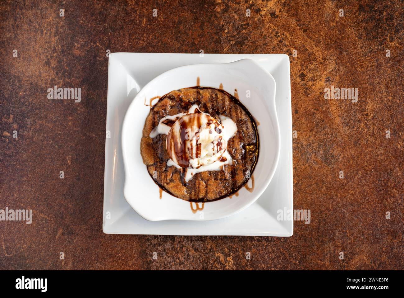 Chocolate Chip Cookie Dough drizzled with chocolate sauce and served with vanilla ice cream Stock Photo