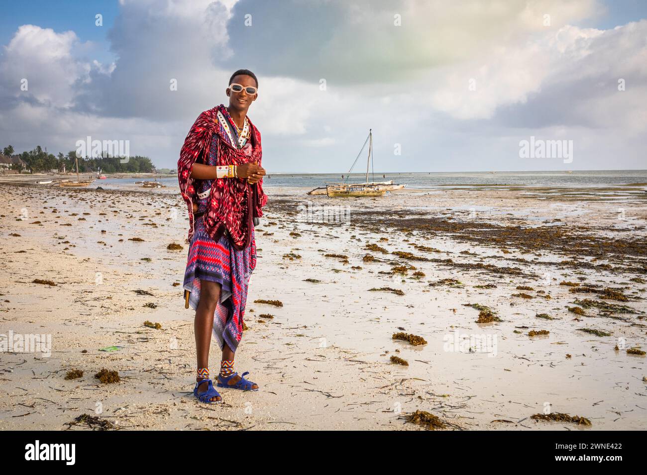 A young Maasai warrior in a traditional shuka on Jambiani beach, Zanzibar, Tanzania Stock Photo
