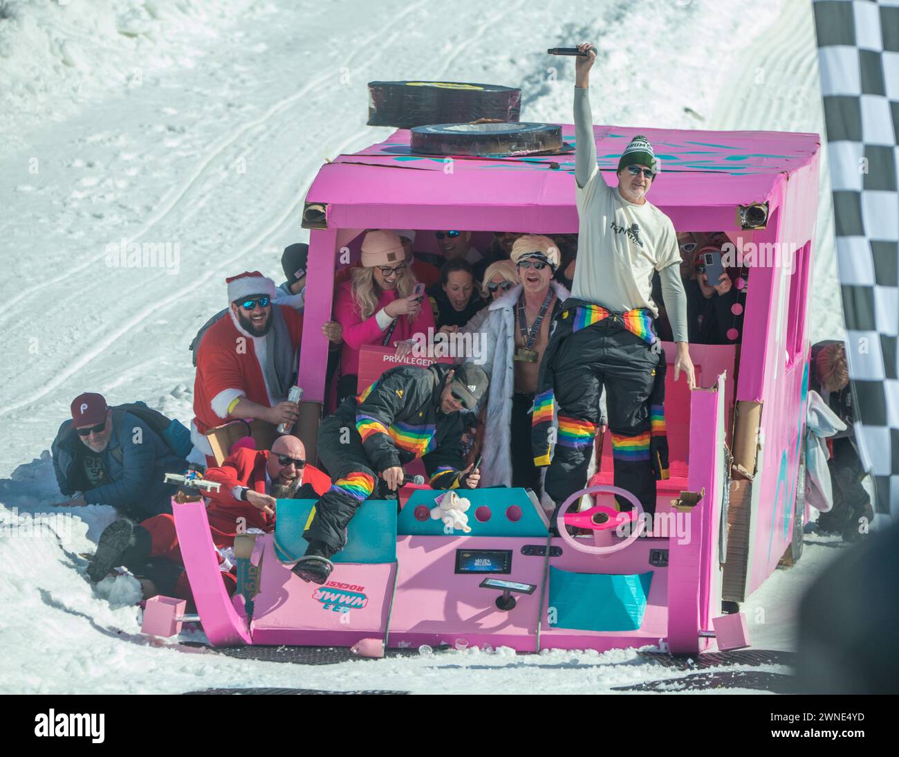 Participants react after sledding down the mountain in their Barbie