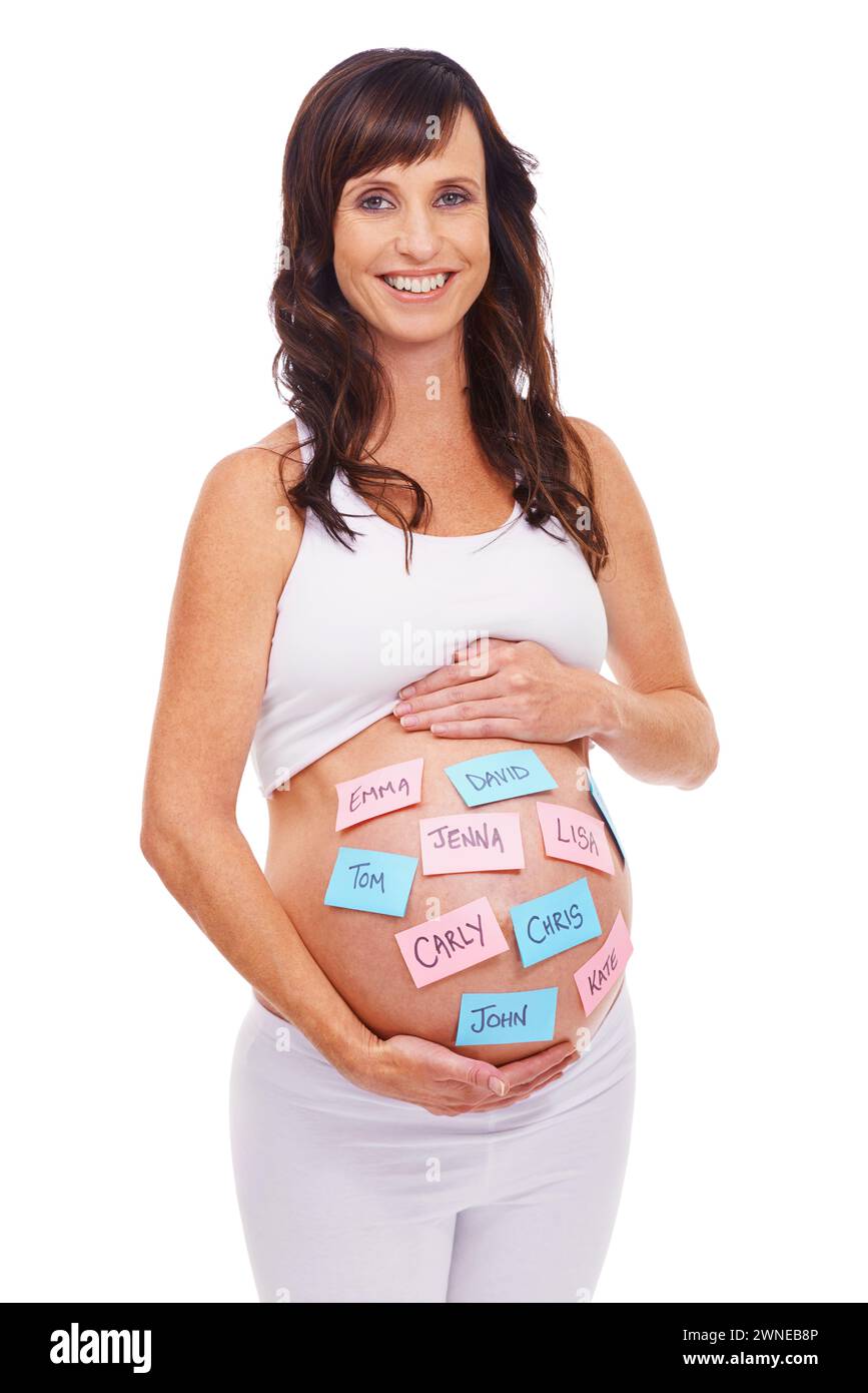 Portrait, names and sticky notes on stomach of pregnant woman with baby in studio isolated on white background. Smile, choice or decision and happy Stock Photo