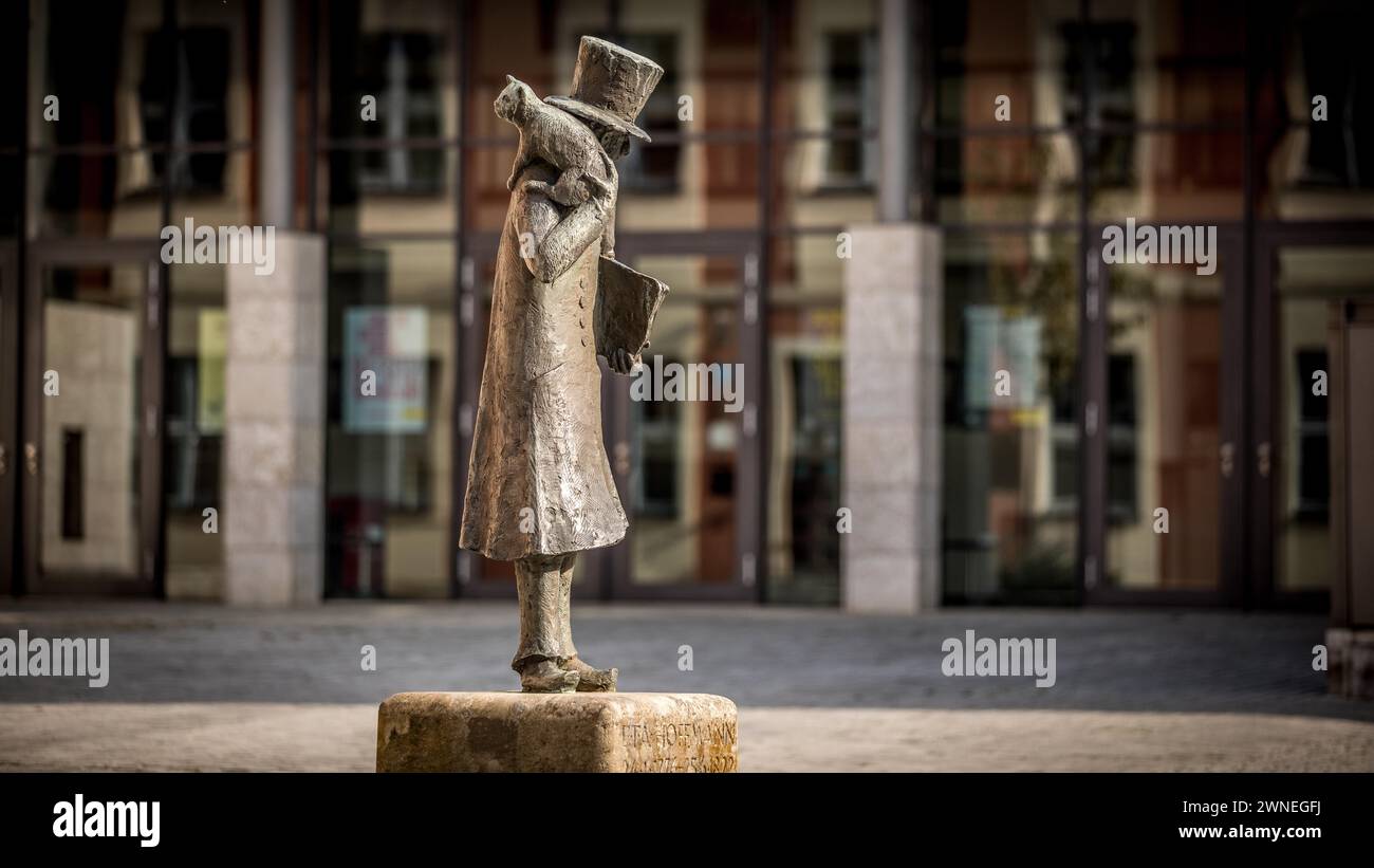 Statue of a man with a top hat and a book on a square surrounded by ...