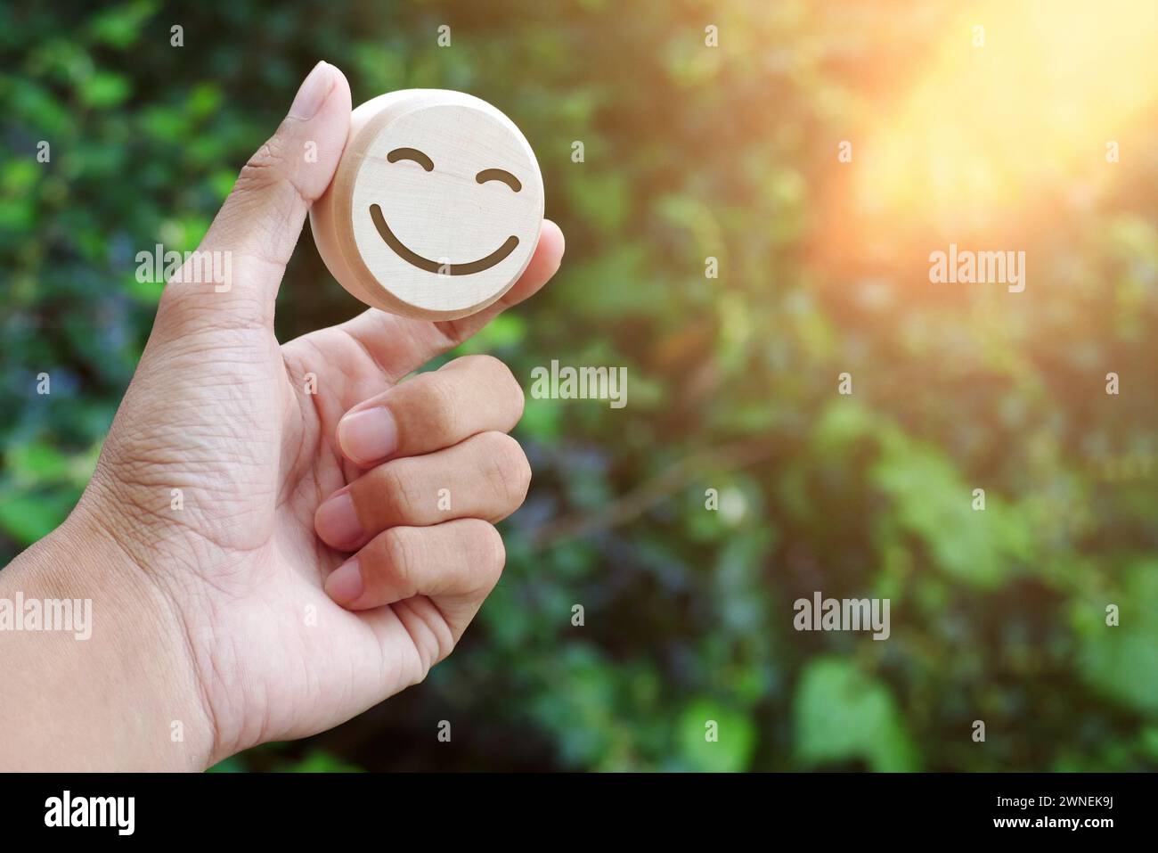 Wooden round with carved happy and angry faces, International Day of Happiness concept, customer reviews, emotional intelligence, emotional control ba Stock Photo