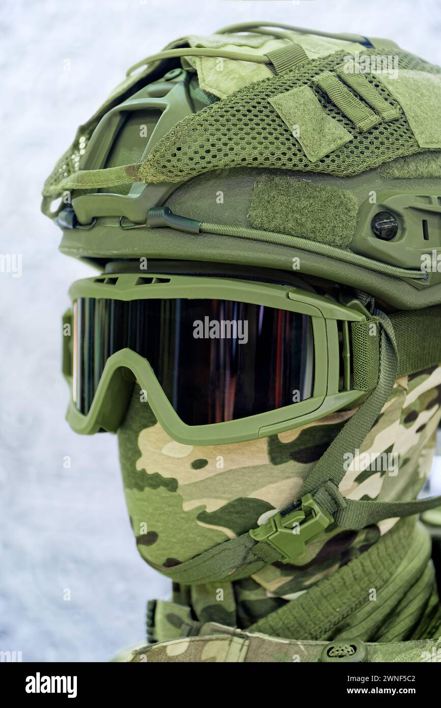 Human mannequin head wearing military protective green camouflage helmet and mask, isolated close-up shot Stock Photo
