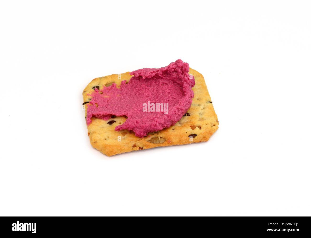 Beet hummus spread on a cracker isolated on white background Stock Photo