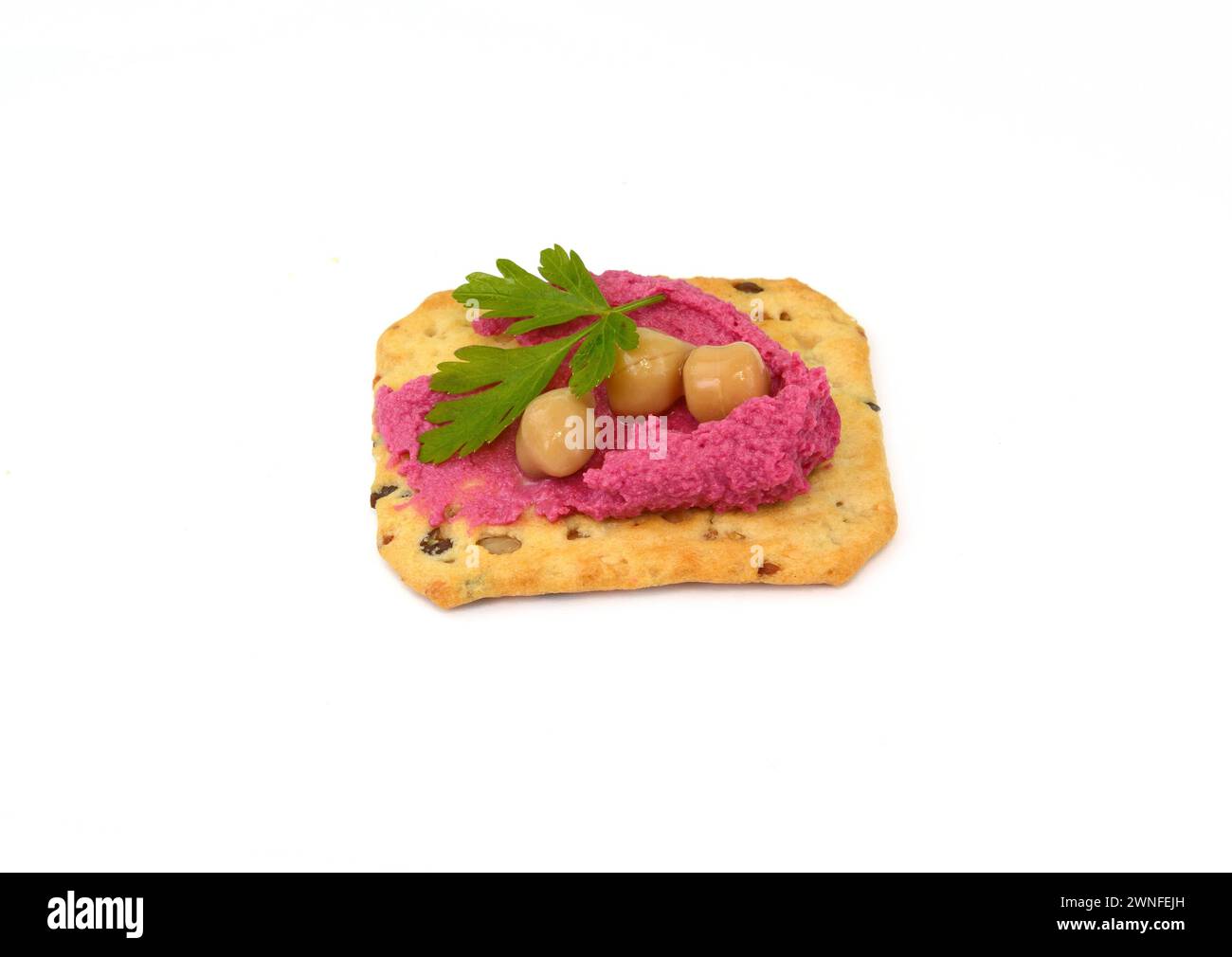 Beet hummus spread on a cracker isolated on white background Stock