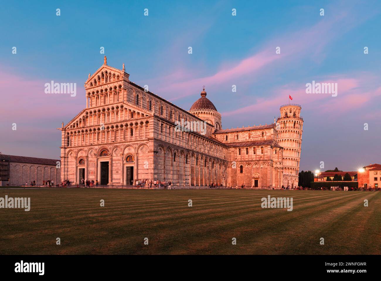 The Cathedral and the Leaning Tower of Pisa glow in the pink light of dusk, Pisa, Tuscany, Italy Stock Photo
