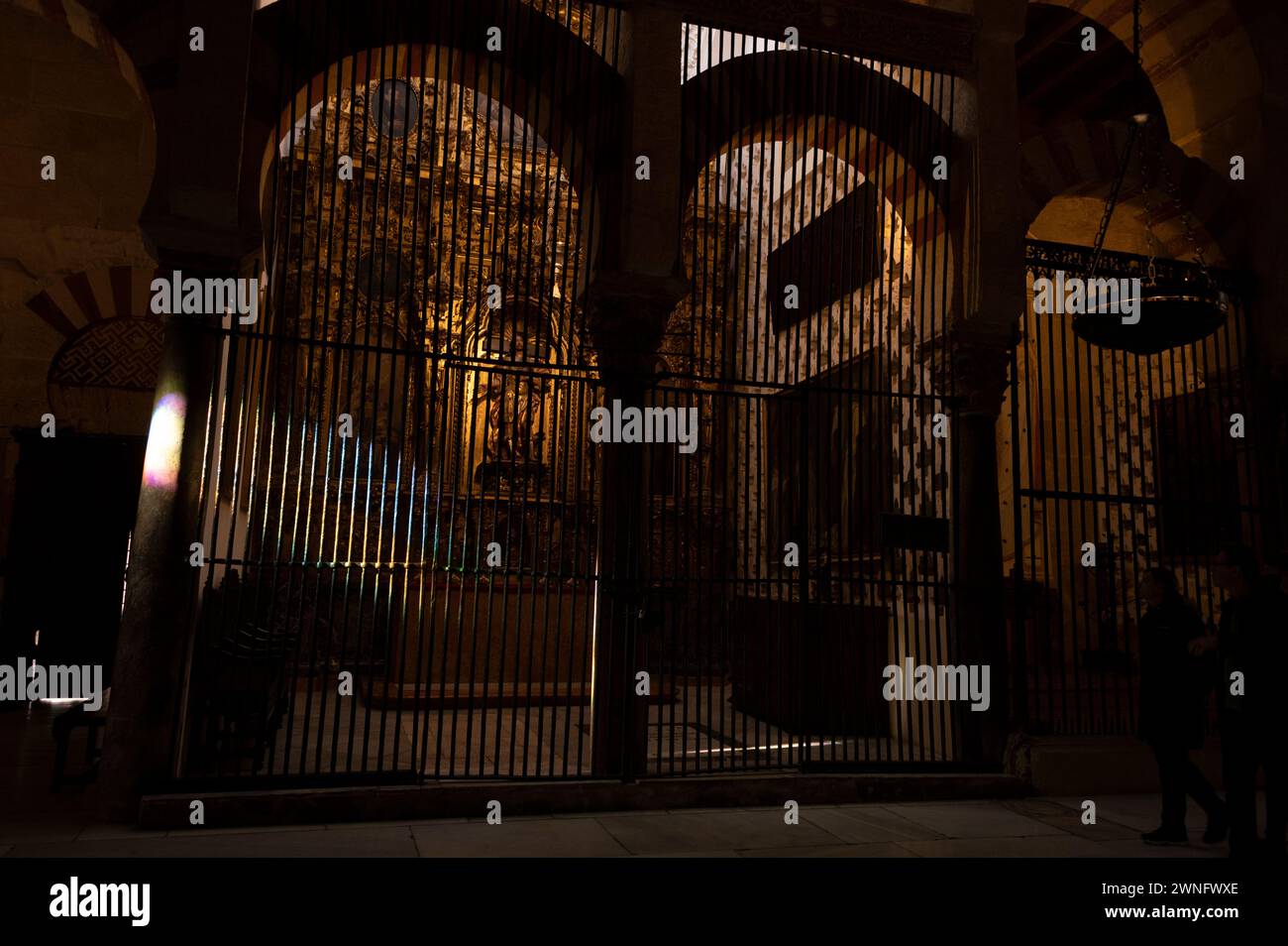 Mosque/ Cathedral of Cordoba  Shards of colour on some of the stone pillars and security grill of one of the Christian funerary chapels and tombs insi Stock Photo