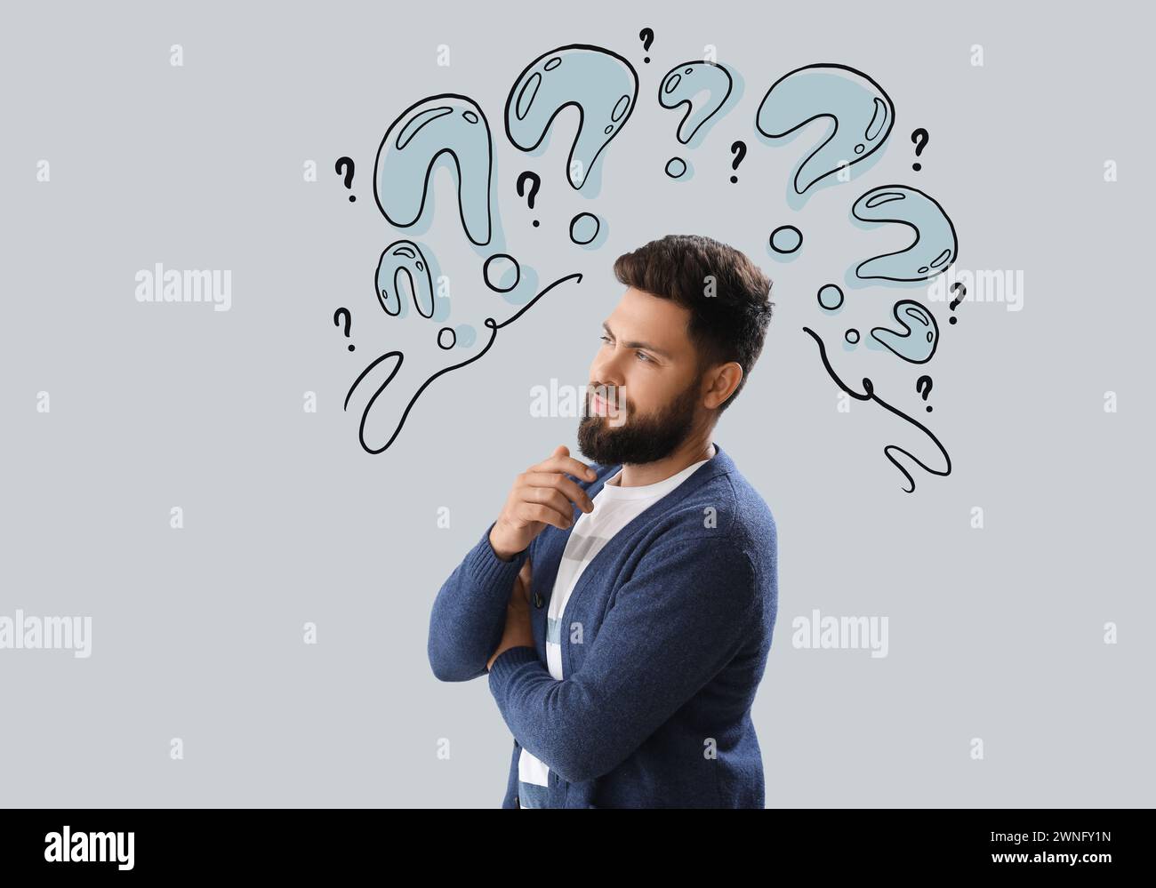 Thoughtful young bearded man on light background Stock Photo