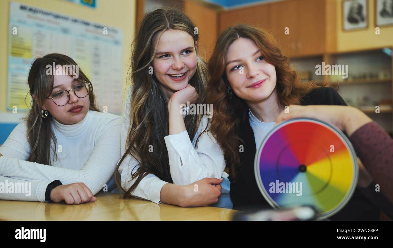 Students in physics class spin Newton's colorful wheel. Stock Photo