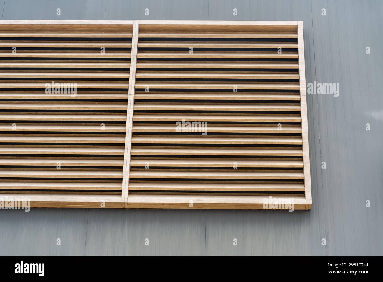 Earthen elegance. wooden planks light brown color on the gray wall . Facade building , background. Stock Photo